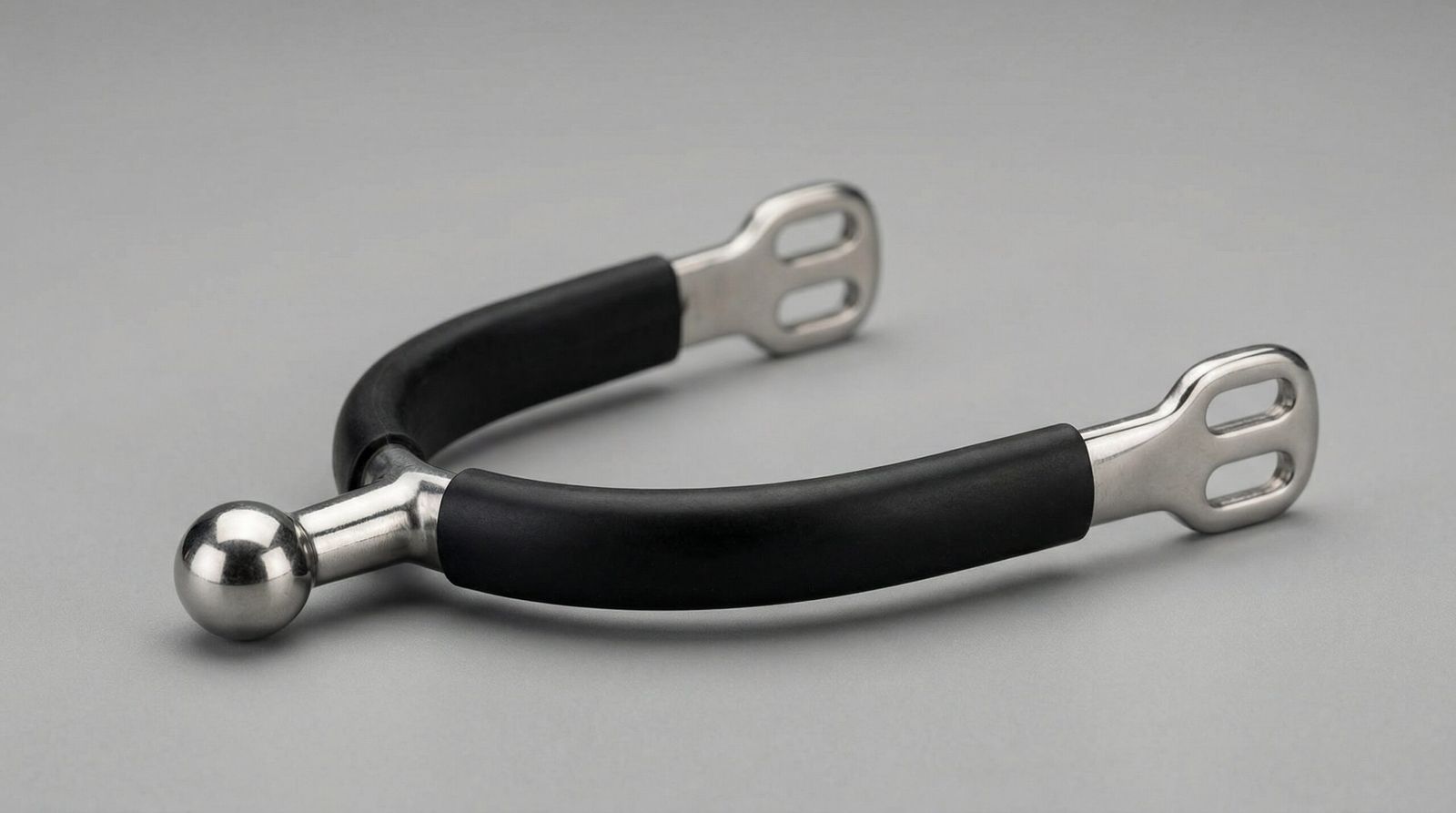 A professional horse ball spur featuring a fixed, non-rotating stainless steel ball and a protective black rubberized heel band.