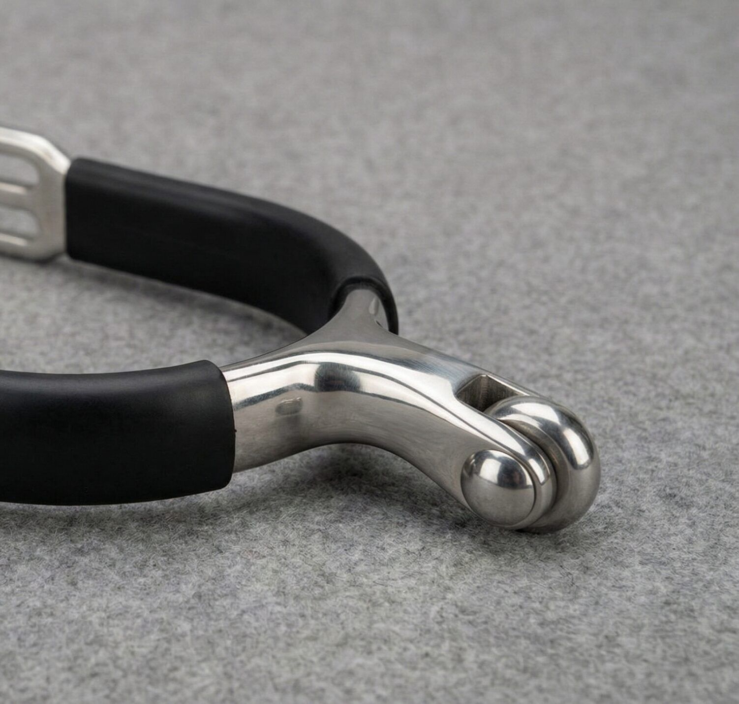 A professional roller ball spur featuring a smooth rotating ball mechanism and a protective black rubberized heel band.